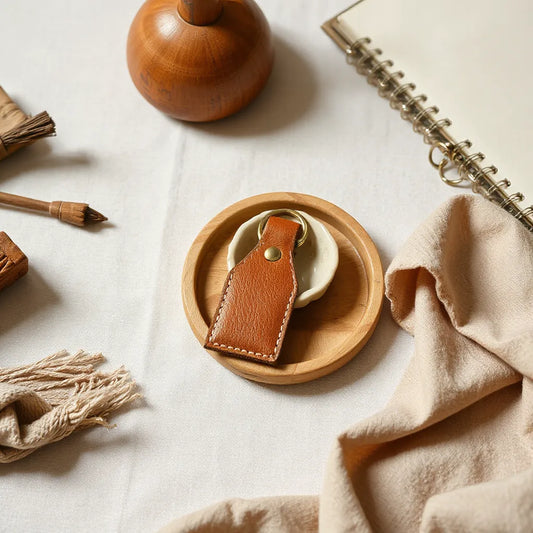 Handmade leather, ceramic, and wood accessories arranged on a warm tabletop