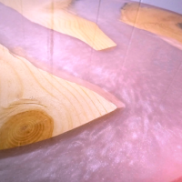 Wooden triangle block on a pink textured surface