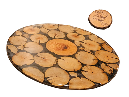 Wooden cutting board with a unique grain pattern and a smaller round wooden brand signon a white background.