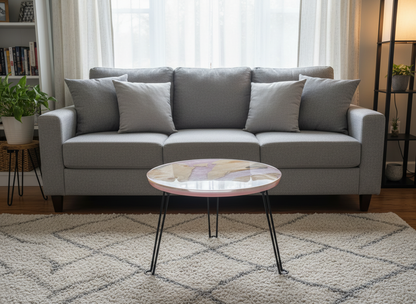 Gray sofa with cushions in a living room setting with a round coffee table.
